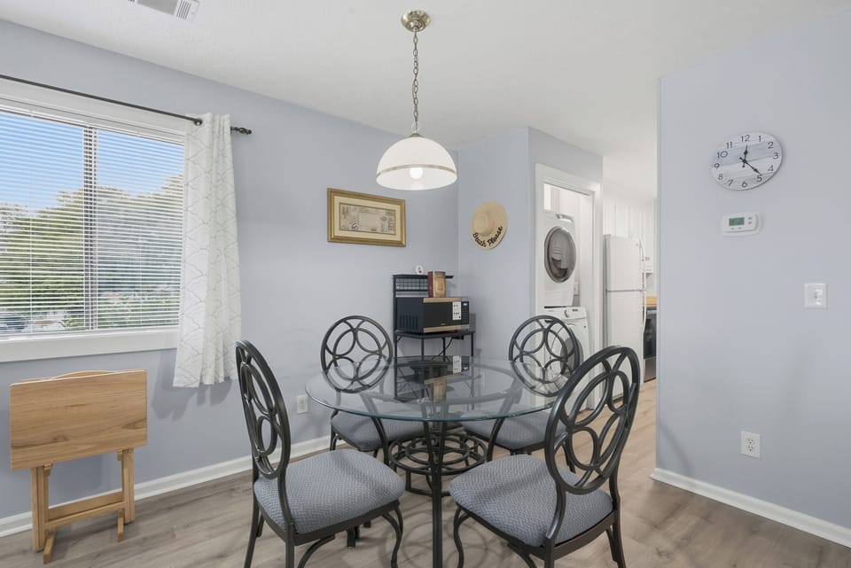 Gather around your elegant glass dining table for morning coffee or evening meals, with natural light streaming through your window.