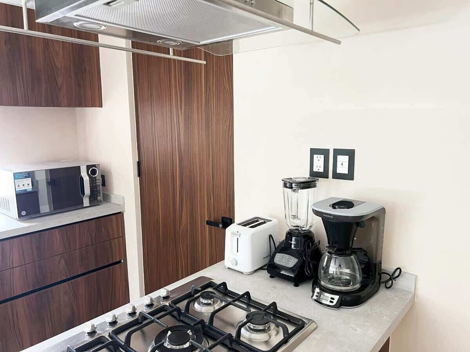 Cocina con electrodomésticos para largas estancias ☕
Detalle del área de preparación con cafetera, microondas, licuadora y tostador. Ideal para quienes buscan comodidad y funcionalidad.