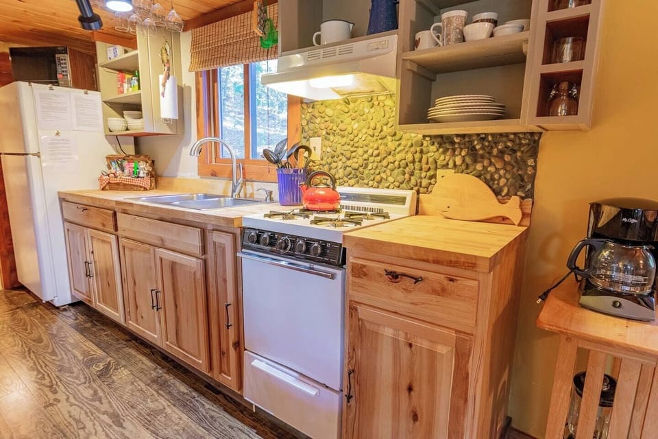 Fully stocked kitchen including spices, dishes, utensils, pots, pans, teapot, blender, microwave, gas stove, refrigerator/freezer, toaster, drip and Keurig coffee machines.