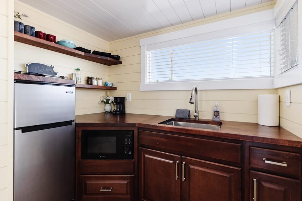 Well-equipped kitchen with a refrigerator, microwave, sink, coffee maker, cookware, dishes, and counter space. Perfect for preparing meals, snacks, and morning coffee during your Southern Utah getaway.