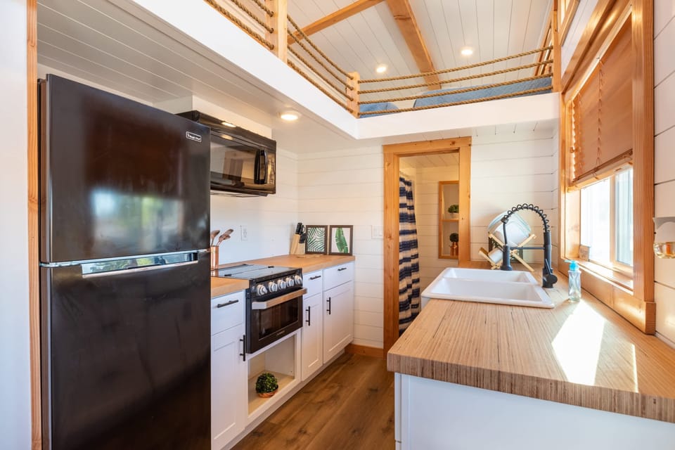 The kitchen is fully equipped with a refrigerator, freezer, microwave, stovetop and oven, and sink with hot/cold water. Enjoy coffee from the coffee maker, with cookware, dishes, utensils, and plenty of storage cabinets to keep everything organized.