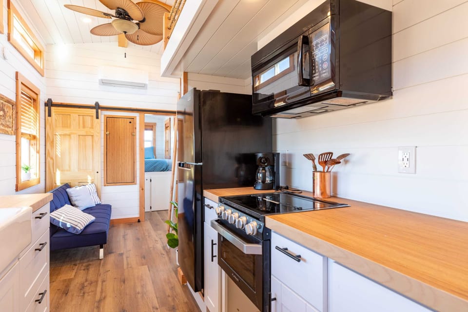 The kitchen is fully equipped with a refrigerator, freezer, microwave, stovetop and oven, and sink with hot/cold water. Enjoy coffee from the coffee maker, with cookware, dishes, utensils, and plenty of storage cabinets to keep everything organized.