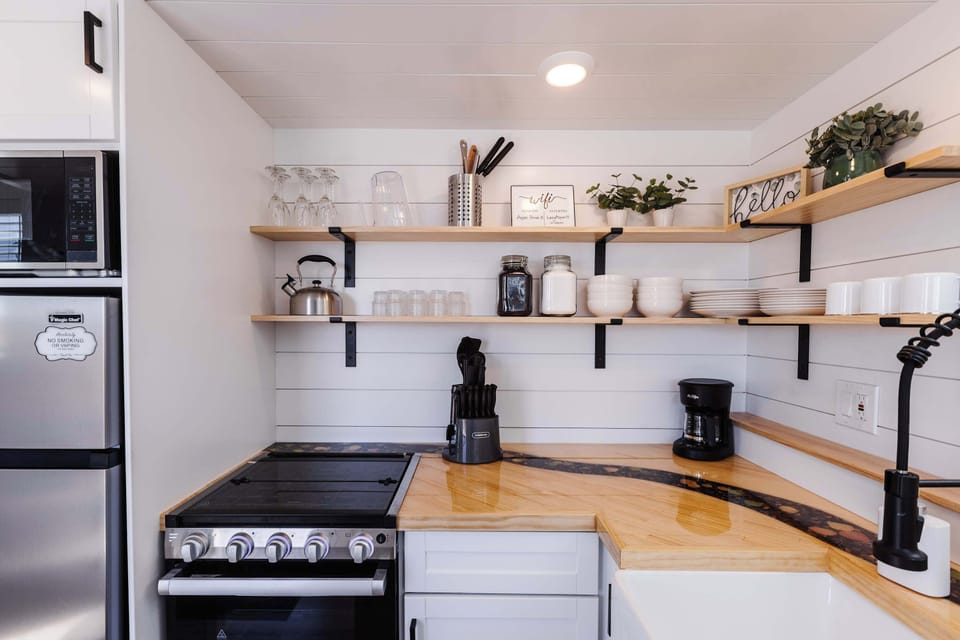 Cozy kitchen with open wood shelving, cookware, dishes, and coffee maker, thoughtfully arranged for a comfortable Southern Utah stay.