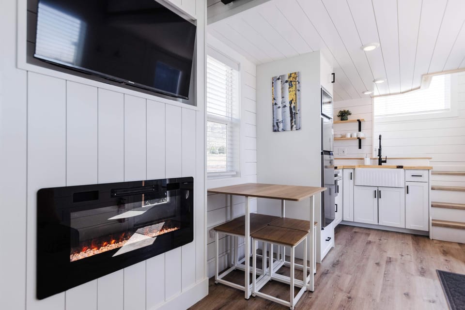 Bright dining area with table seating beside the electric fireplace, offering a cozy spot for meals during a Southern Utah getaway.