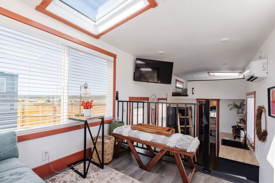 The open living area connects seamlessly to the loft and kitchen, creating a spacious layout with plenty of natural light, comfortable seating, and a Smart TV for relaxing after your adventures.