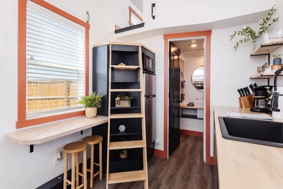 Enjoy a functional kitchen with modern appliances, open shelving, a coffee maker, and a breakfast bar with seating for two. Perfect for morning coffee or a quick meal before exploring.