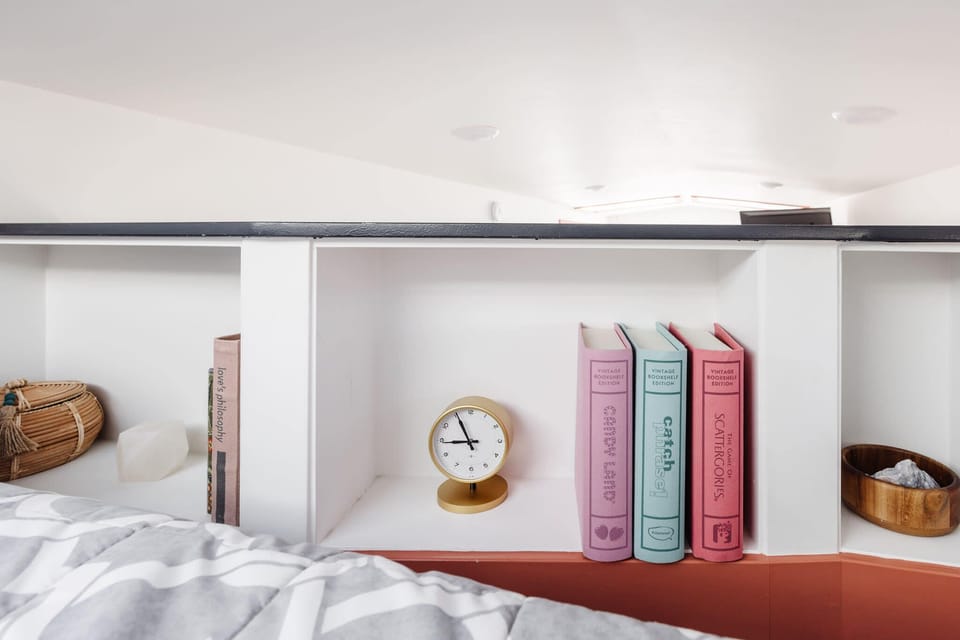 Built-in shelving beside the queen bed provides convenient storage for books, personal items, and travel essentials, helping keep the loft bedroom organized and comfortable throughout your stay.