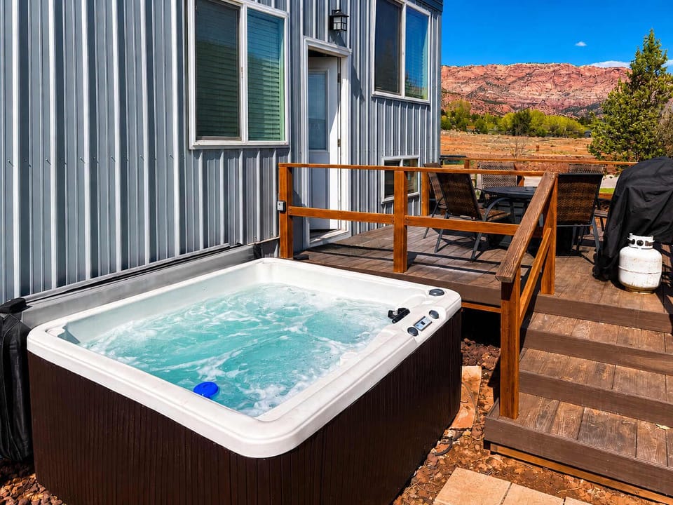 Relax in the private hot tub after a day exploring Southern Utah. The spacious deck features outdoor dining, a BBQ grill, and beautiful red rock scenery, creating the perfect place to unwind morning or night.