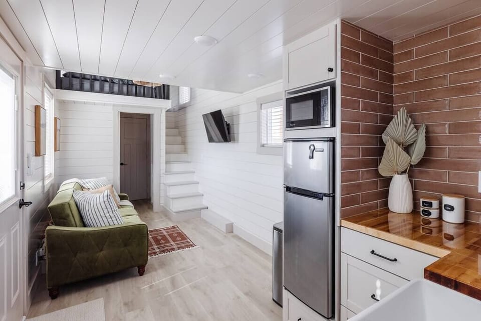 The kitchen is fully equipped with a refrigerator, freezer, microwave, cooktop, and sink with hot/cold water. Enjoy coffee from the coffee maker, with cookware, dishes, and utensils.