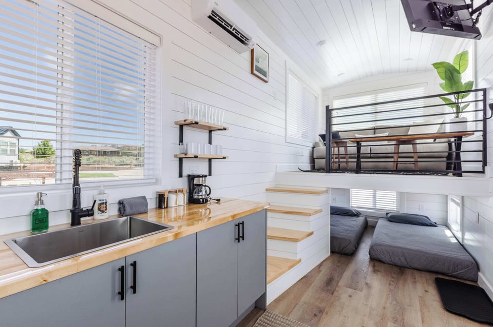 Smart tiny home design combines a fully equipped kitchen, loft seating area, and comfortable sleeping spaces into one bright, inviting retreat near Zion National Park.