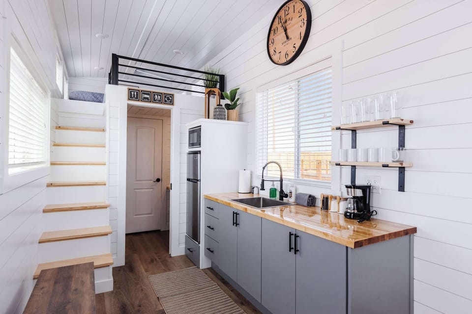 Cook, dine, and recharge in this modern kitchen featuring ample counter space, open shelving, a coffee maker, and all the essentials for preparing meals during your getaway.