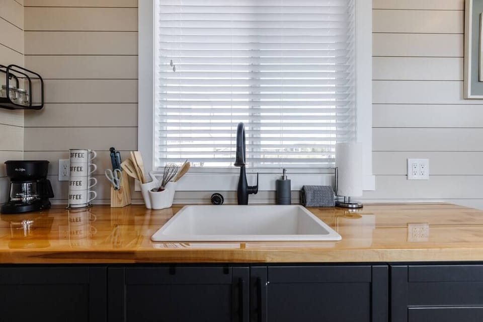 The kitchen is equipped with a refrigerator, freezer, microwave, cooktop, and sink with hot/cold water. Enjoy coffee from the coffee maker and ample counter space. Essentials include cookware, dishes, utensils, and storage cabinets.