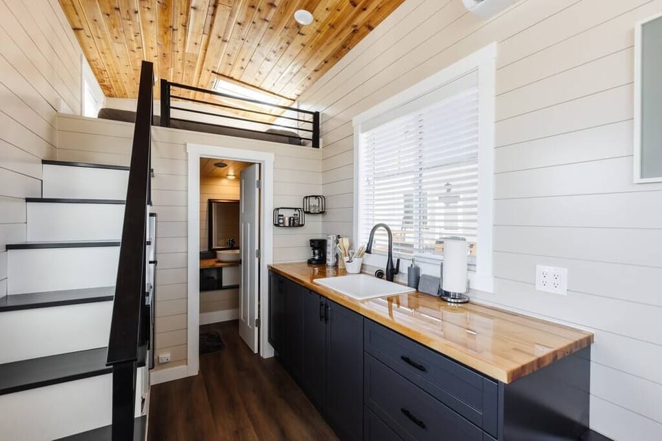 The kitchen is equipped with a refrigerator, freezer, microwave, cooktop, and sink with hot/cold water. Enjoy coffee from the coffee maker and ample counter space. Essentials include cookware, dishes, utensils, and storage cabinets.