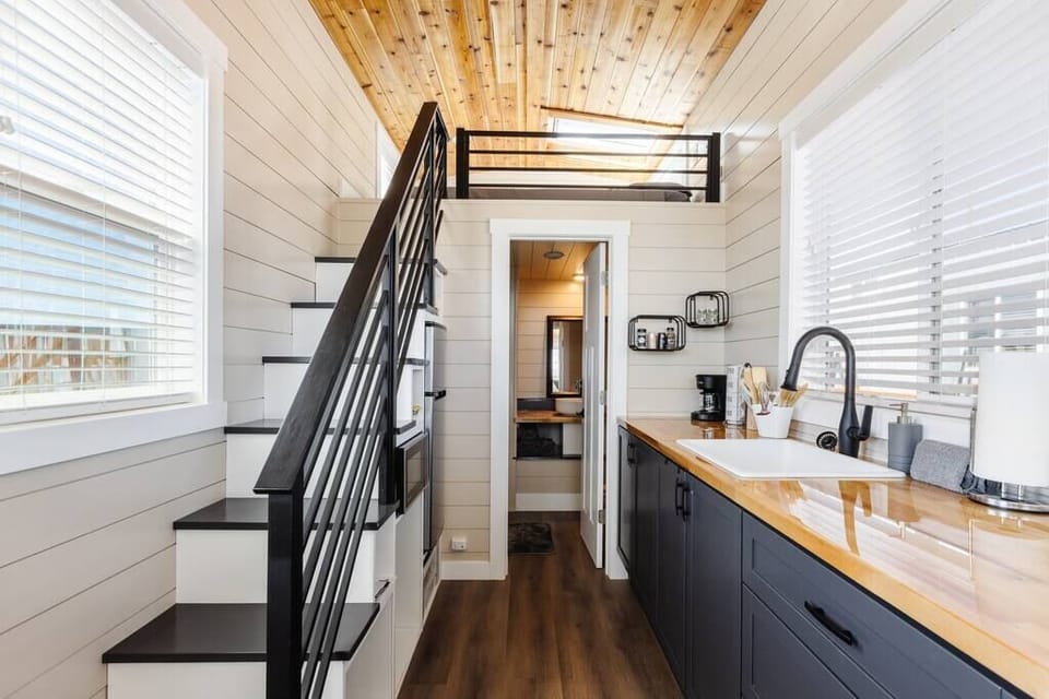 The kitchen is equipped with a refrigerator, freezer, microwave, cooktop, and sink with hot/cold water. Enjoy coffee from the coffee maker and ample counter space. Essentials include cookware, dishes, utensils, and storage cabinets.