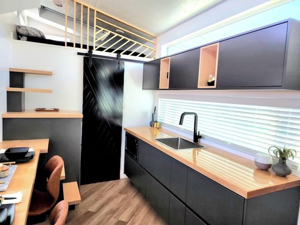 The kitchen is fully equipped with a refrigerator, freezer, microwave, cook-top, and sink with hot/cold water. Enjoy coffee from the coffee maker and ample counter space. Essentials include cookware, dishes, and utensils.