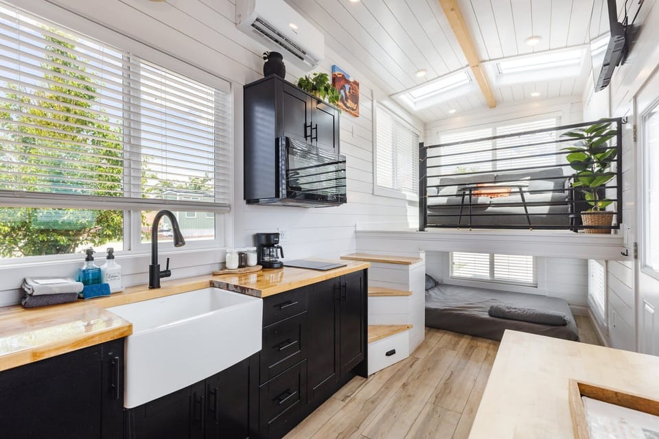 The kitchen is fully equipped with a refrigerator, freezer, microwave, stovetop, and sink with hot/cold water. Enjoy coffee from the coffee maker, with cookware, dishes, utensils, and plenty of storage cabinets to keep everything organized.
