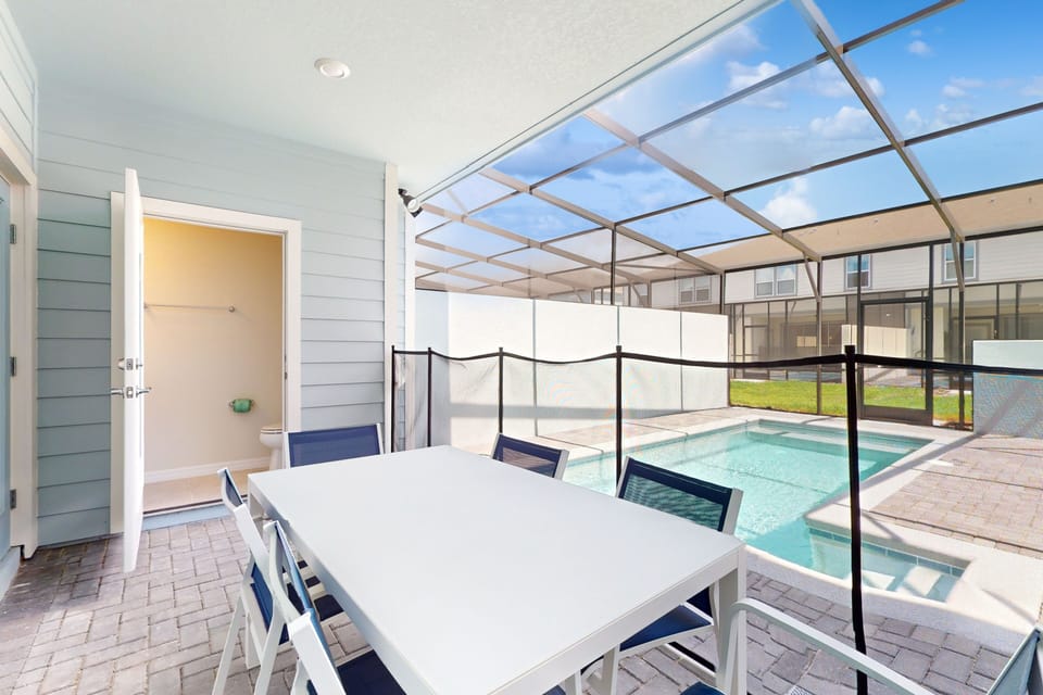 Private lanai with dining table, loungers & 1/2 bath