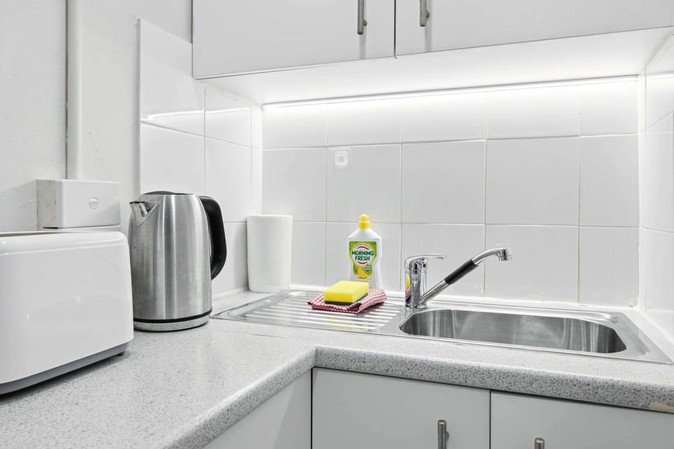 Well-equipped kitchen area featuring sink, kettle, and essential appliances.