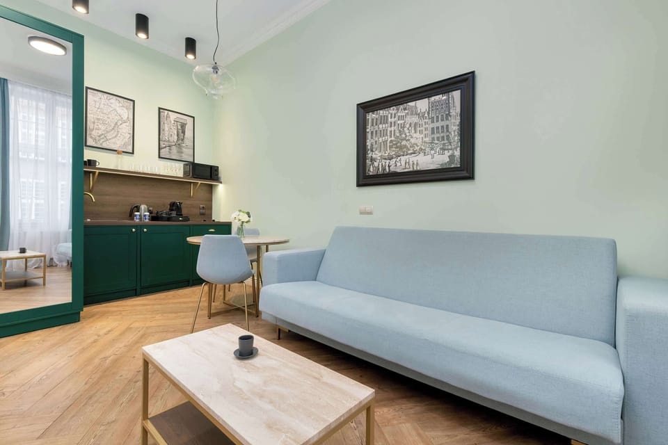 The seating area with a light-colored sofa, wooden coffee table, and minimalist decor creating a relaxed atmosphere.