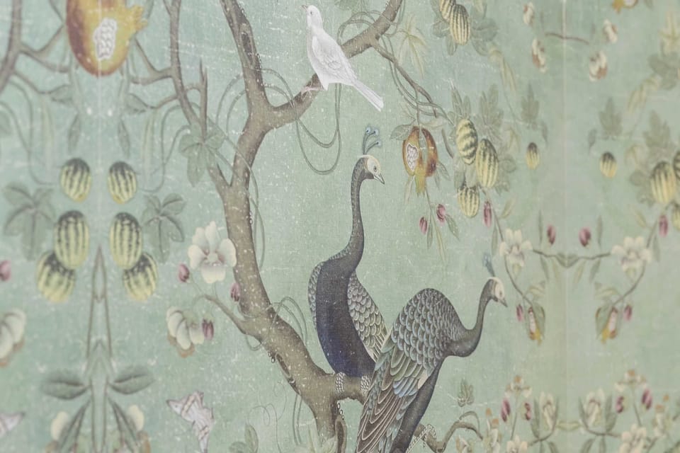 A detailed close-up of the botanical-patterned wallpaper featuring birds and tree branches in muted tones.