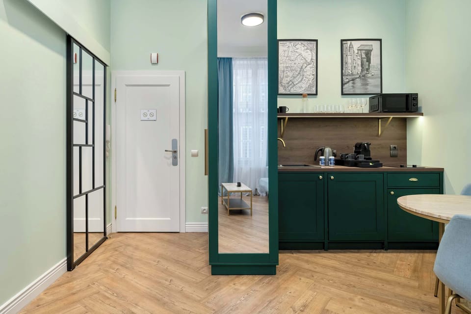 An entrance hallway view leading toward the kitchenette, with clean lines and coordinated green accents.