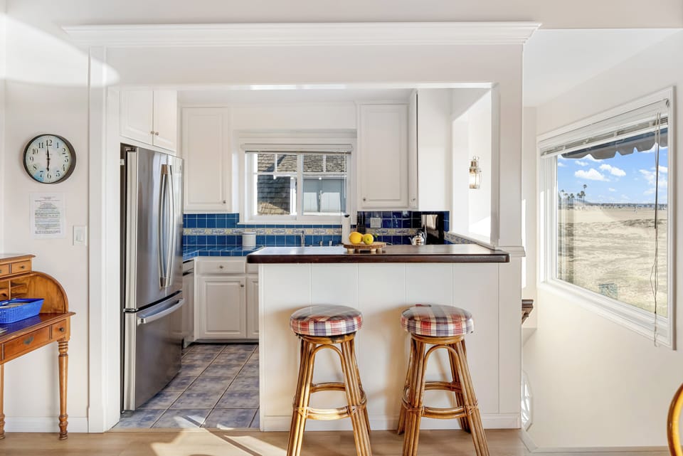 Bright coastal kitchen with breakfast bar and ocean views.