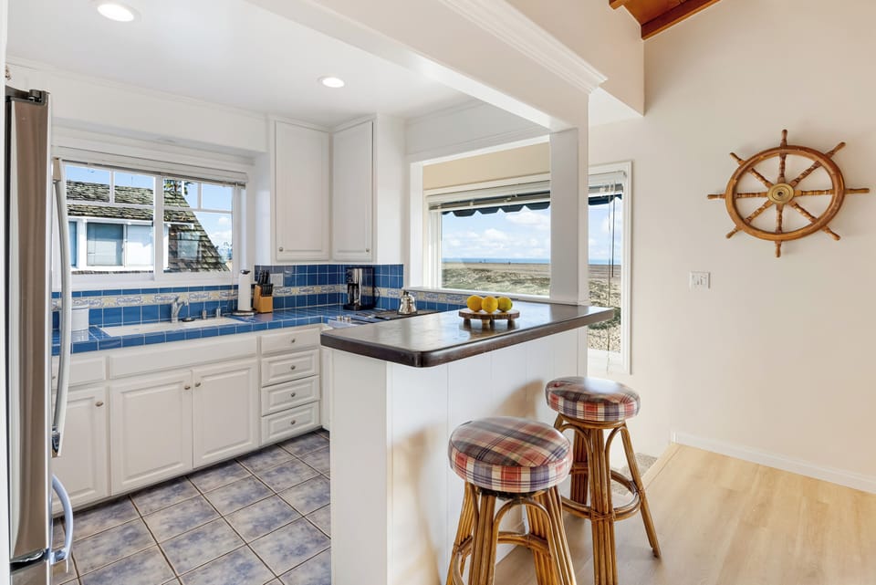 Bright coastal kitchen with breakfast bar and ocean views.