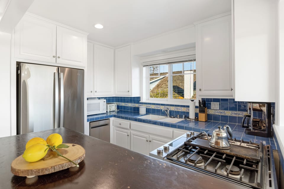 Bright coastal kitchen with breakfast bar and ocean views.