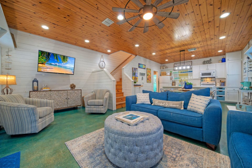 Bright, coastal-inspired living space with vaulted wood ceilings—perfect for gathering, relaxing, and unwinding after a day at the beach.