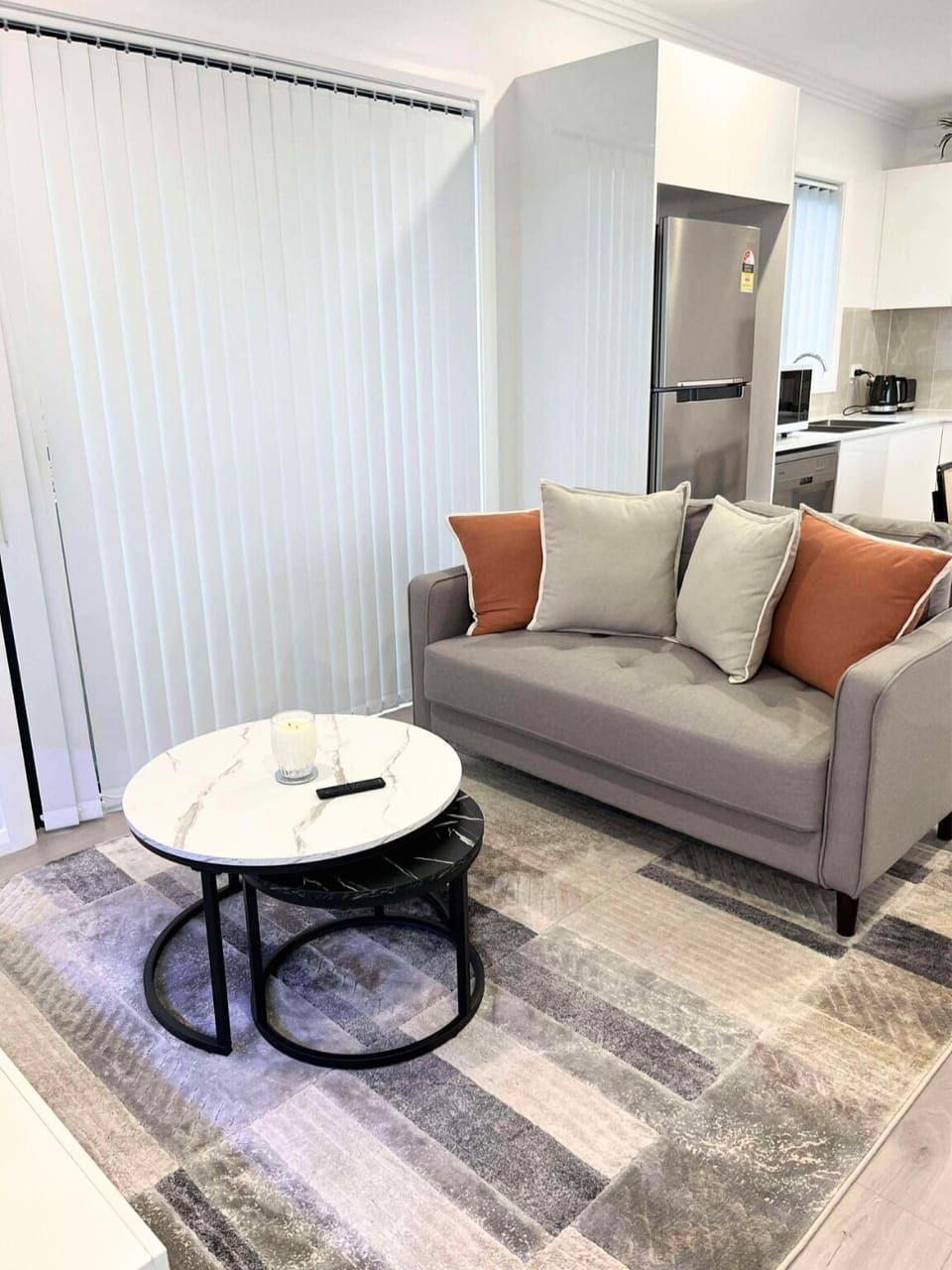 Bright, welcoming living room with comfy sofa, TV, and natural light