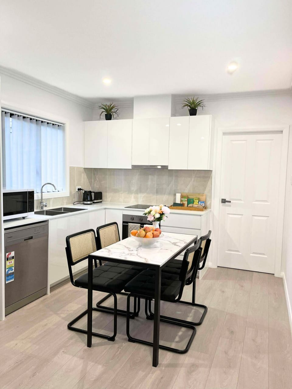 Bright kitchen with fridge, stove, dishwasher, cookware, utensils & dishes