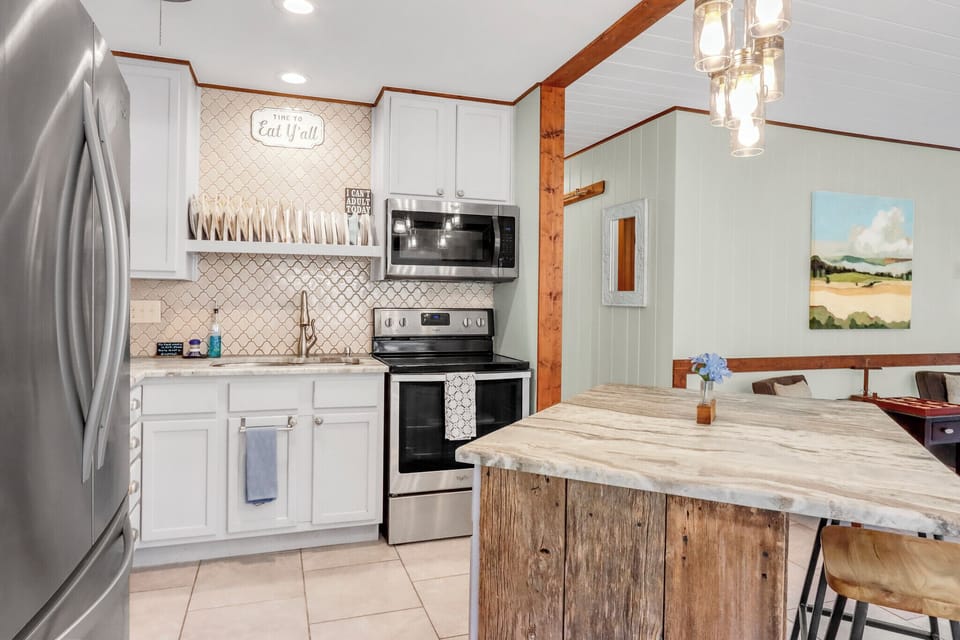 Cook your favorite meals in this charming kitchen featuring granite countertops, stainless steel appliances, and rustic wood beams that add warmth to your stay.