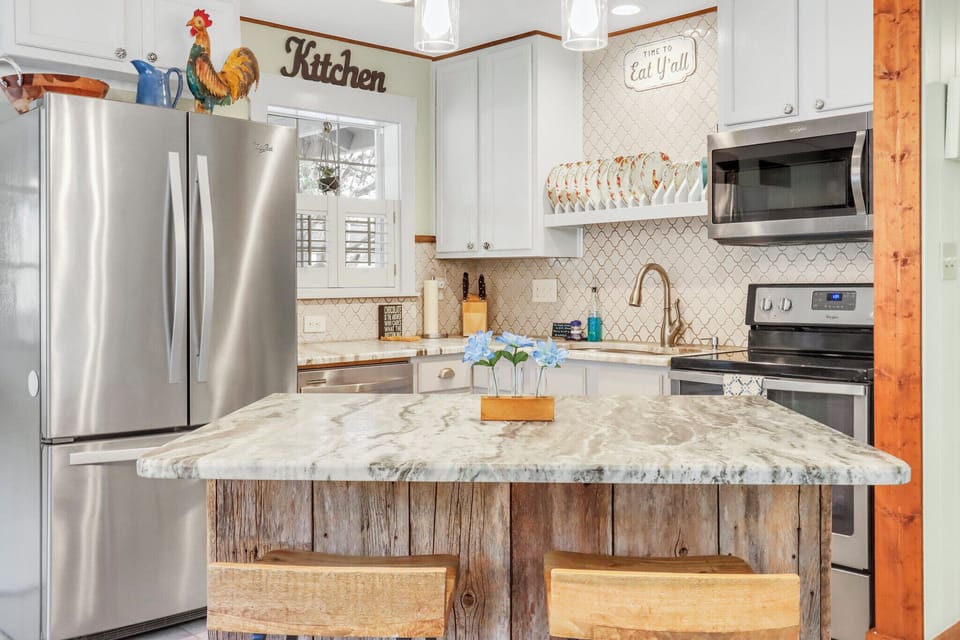 Your fully equipped kitchen blends modern amenities with rustic charm, featuring stainless steel appliances and a stunning marble island perfect for cooking together.