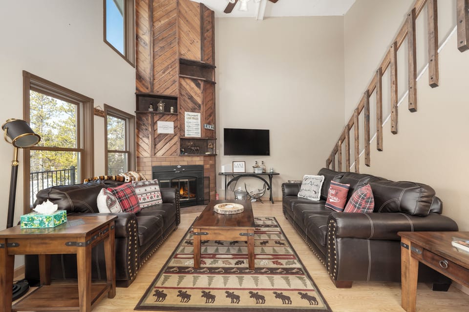 Sink into these plush leather sofas by your crackling fireplace, where rustic charm meets modern comfort in your mountain retreat.