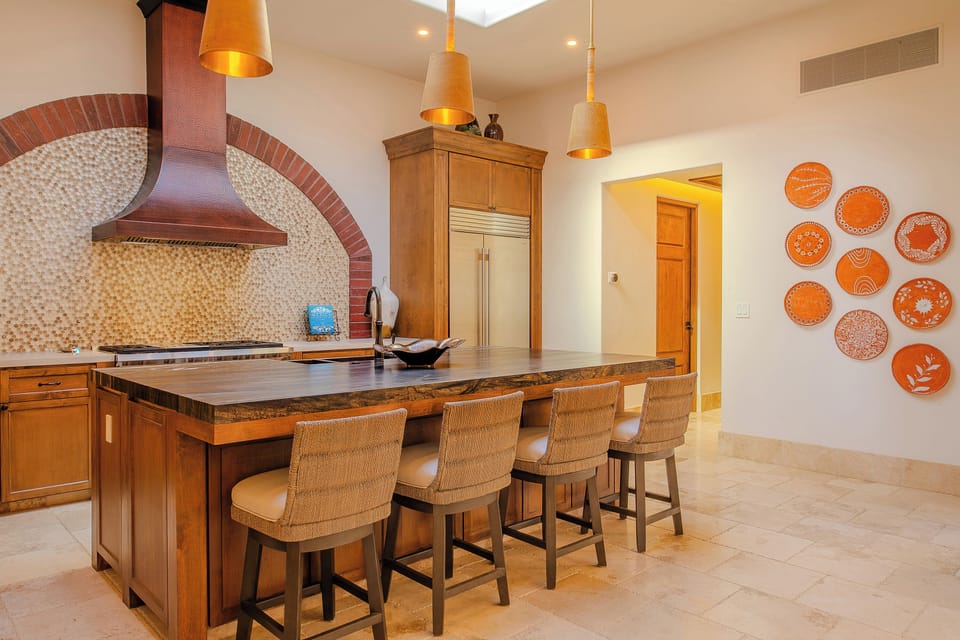 Your spacious kitchen island awaits with warm wood tones and vibrant Mexican tiles creating the perfect space for cooking.