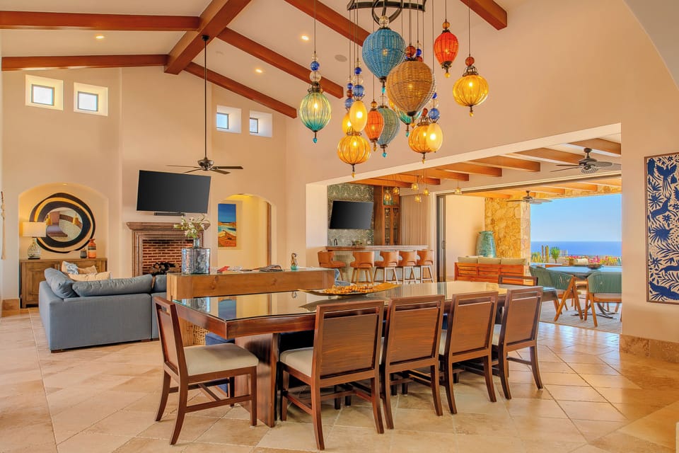 Gather around your stunning dining table beneath artisan pendant lights, with ocean views flowing through open walls.