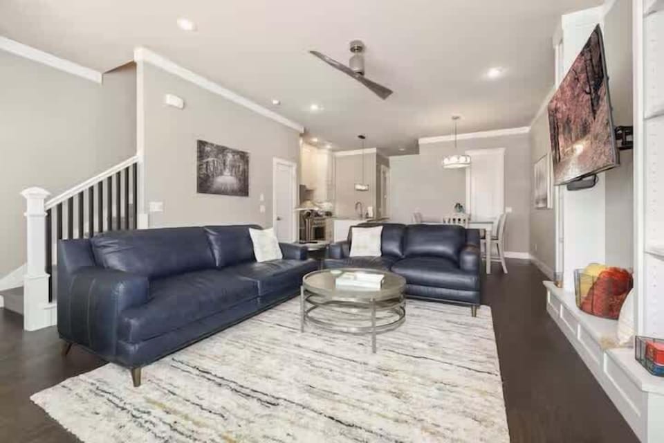 Open-concept living room with comfy leather sofas and a Smart TV for movie nights.