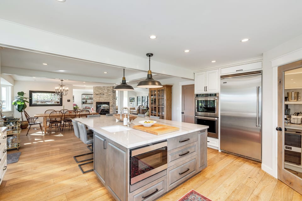 Your gourmet kitchen features a spacious island, stainless steel appliances, and pendant lighting, perfect for cooking memorable meals together.