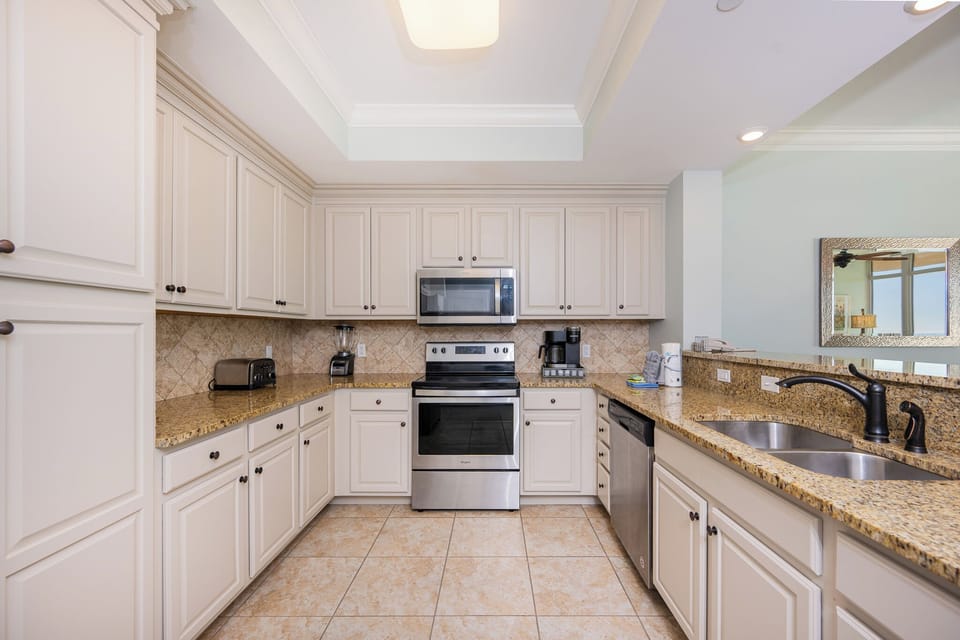 Prepare meals in this kitchen with elegant cabinetry, stainless appliances, and spacious countertops
