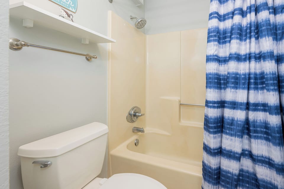Blue and white curtain adds coastal charm to your master bath with a tub/shower combo for relaxing rinses