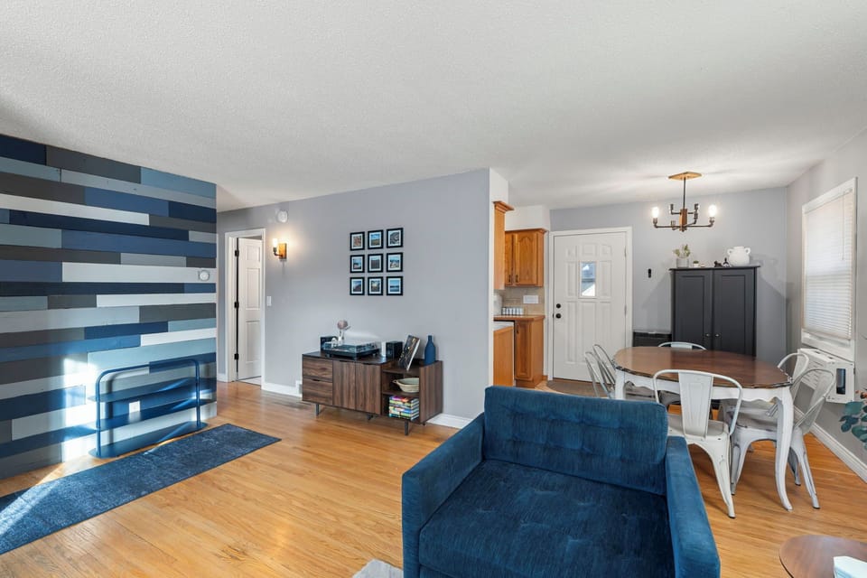 Relax in your stylish open living space with modern blue accents, warm wood floors, and everything you need for a comfortable stay.