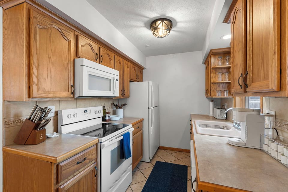 Your fully equipped kitchen features warm oak cabinets, modern appliances, and ample counter space for preparing memorable meals.