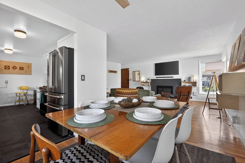 Bright open-concept dining & lounge with fireplace and sleek kitchen.