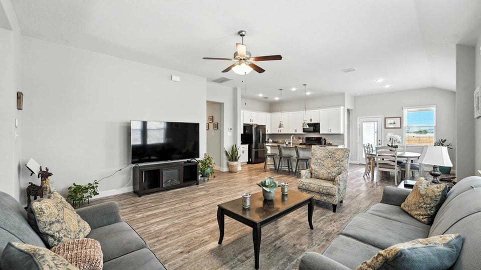 Wide-angle view of the open living, dining, and kitchen space—easy flow that works well for everyday living.
