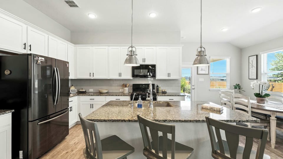 Open kitchen with white cabinetry, stainless steel appliances, and plenty of counter space—fully set up for real-life cooking.