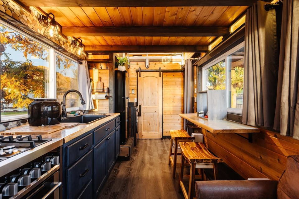 Fully equipped kitchen with wood countertops, modern appliances, a gas range, and stylish cabinetry. Bright windows and thoughtful design make cooking easy, functional, and enjoyable in this cozy tiny home.