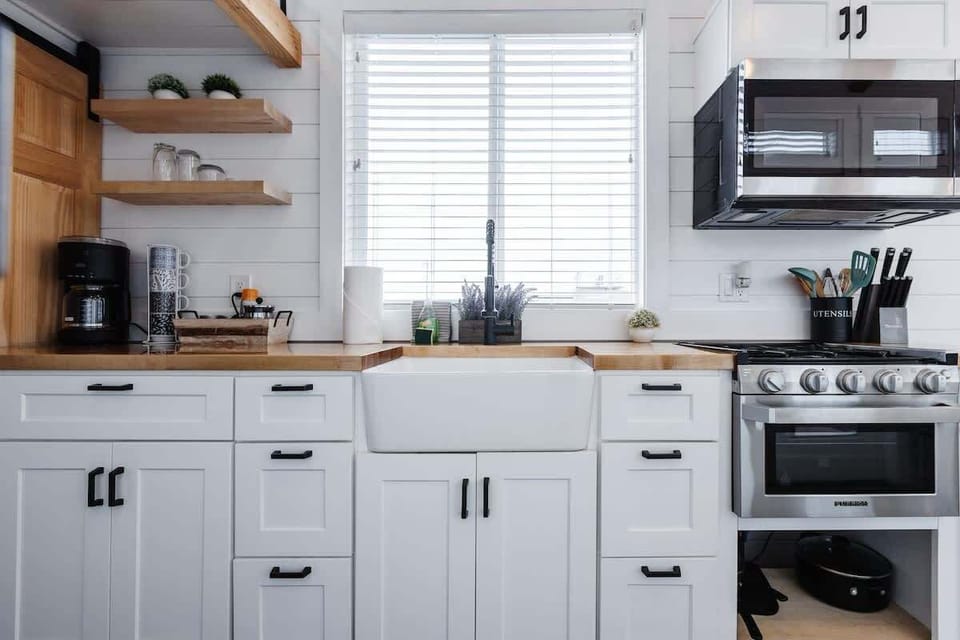Fully equipped kitchen with farmhouse sink, full gas stove and oven, microwave, and cookware provided for easy meal prep during your Zion getaway.
