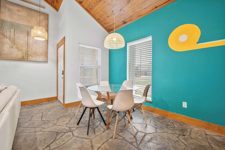 A stylish dining room with vibrant coastal colors and natural light offering the perfect space for relaxed seaside meals.