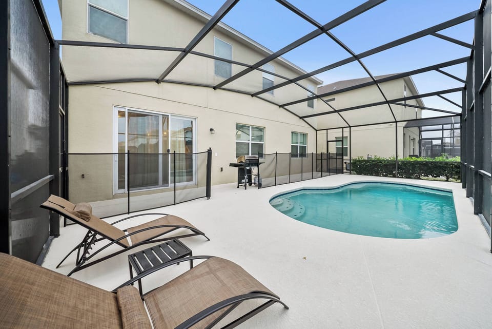Step outside to enjoy your private screened patio featuring a shimmering pool, perfect for an afternoon dip. Relax on sleek lounge chairs as sunlight filters through the mesh, creating a bright and airy atmosphere for your stay.