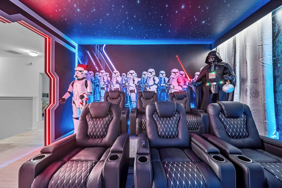 Experience a cinematic dream in our themed home theater, complete with plush leather recliners, vibrant galaxy-inspired lighting, and stunning decor featuring iconic figures for an unforgettable movie night.